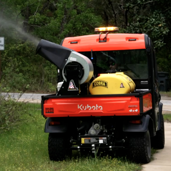 A man holds a briquet over a stream which has stangnat water.